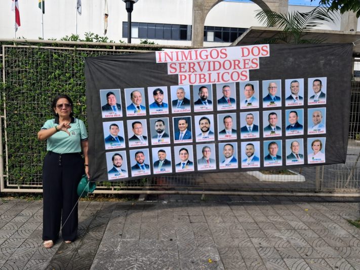 Elma Sampaio, presidente da Asprom Sindical, e o painel com fotos de vereadores que votaram a favor de alterações na aposentadoria de servidores (Foto: Asprom/Divulgação)