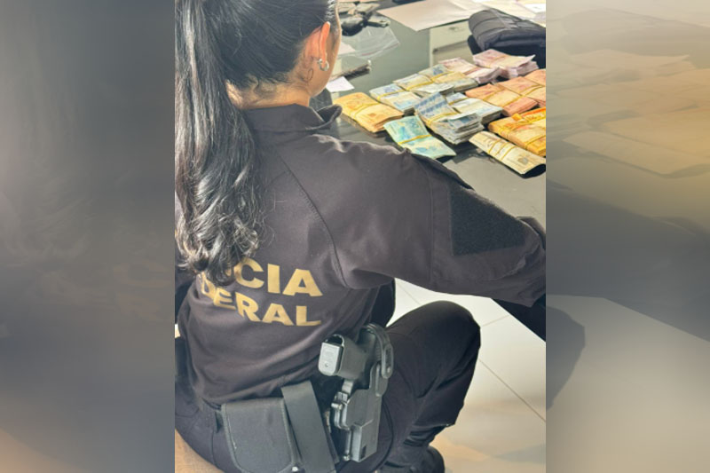 Agente federal recolhe dinheiro apreendido em endereço de Antônio Doido (Foto: PF/Divulgação)