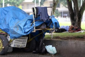 Pessoa que vive na rua dorme em gramado de praça: cresce a população de rua no Brasil (Foto: Tânia Rêgo/ABr)