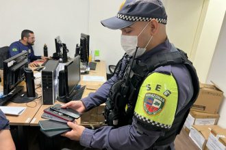 Policial inspeciona celulares recuperados: redução no número de roubos (Foto: Victor Levy/SSP-AM)