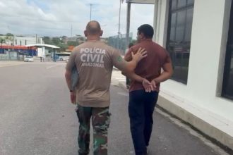 Momento em que o homem é levado à delegacia por policial civil (Foto: WhatsApp/Reprodução)