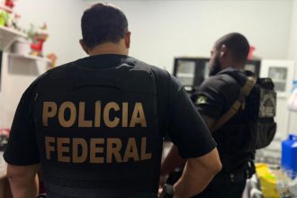 Agentes federais colhem documentos em casa de suspeito (Foto: PF/Divulgação)