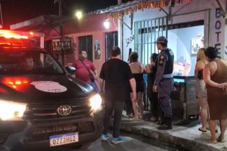 Policiais e vizinhos em frente ao estabelecimento: comerciante foi morto a tiros (Imagem: Reprodução/Facebook)