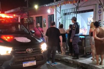 Policiais e vizinhos em frente ao estabelecimento: comerciante foi morto a tiros (Imagem: Reprodução/Facebook)