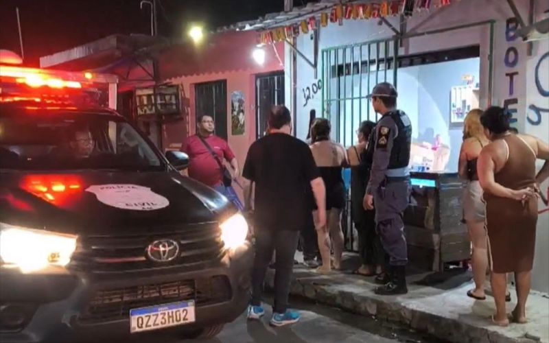 Policiais e vizinhos em frente ao estabelecimento: comerciante foi morto a tiros (Imagem: Reprodução/Facebook)
