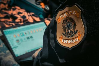 Agente federal verifica computador com imagens de mulheres: combate a estupros (Foto: PF/Divulgação)