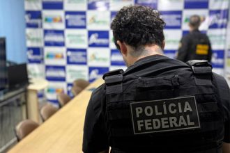 Agente federal inspeciona documentos em operação que apura uso de recursos da previdência no Banco Master (Foto: PF/Divulgação)