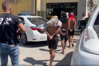 Agressores no momento em que chegaram a delegacia. Eles foram identificados por imagens de câmera de monitoramento (Imagem: G1/YouTube/Reprodução)
