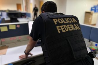 Agente federal inspeciona computador em operação de combate a crimes de ódio (Foto: PF/Divulgação)