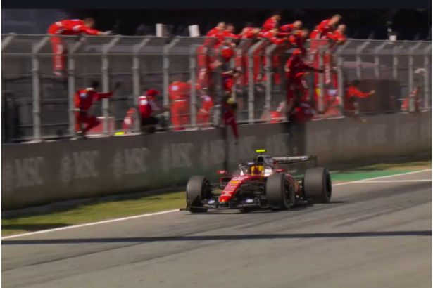 Lewis Hamilton cruza a linha de chegada em primeiro e é celebrado pelos mecânicos da Ferrari (Imagem: Ferrari/YouTube/Reprodução)