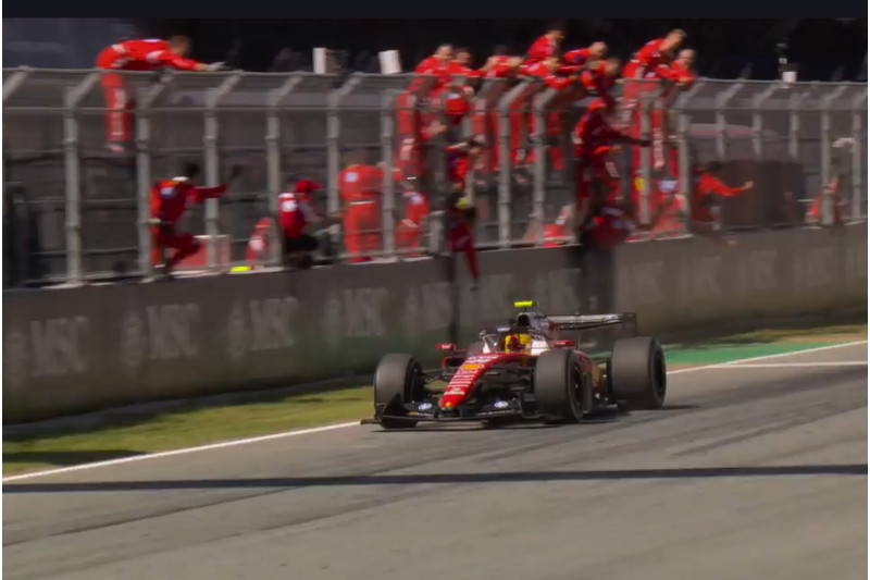 Lewis Hamilton cruza a linha de chegada em primeiro e é celebrado pelos mecânicos da Ferrari (Imagem: Ferrari/YouTube/Reprodução)