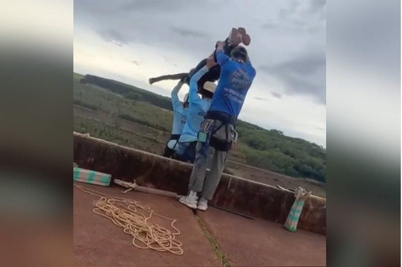 Momento em que Maria Eduarda é erguida para ser lançada da ponte (Imagem: Facebook/Reprodução
