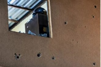 Os policiais que atenderam a ocorrência encontraram marcas de tiros na fachada e nas paredes do imóvel (Foto: WhatsApp/reprodução)