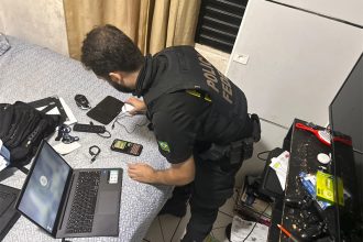 Agente federal inspeciona computador em casa de suspeito em Manicoré (Foto: PF/Divulgação)