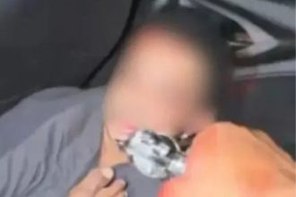 Imagem mostra Jordan Lima em um veículo, sob a mira de um revólver e com ferimento na cabeça (Foto: WhatsApp/reprodução)